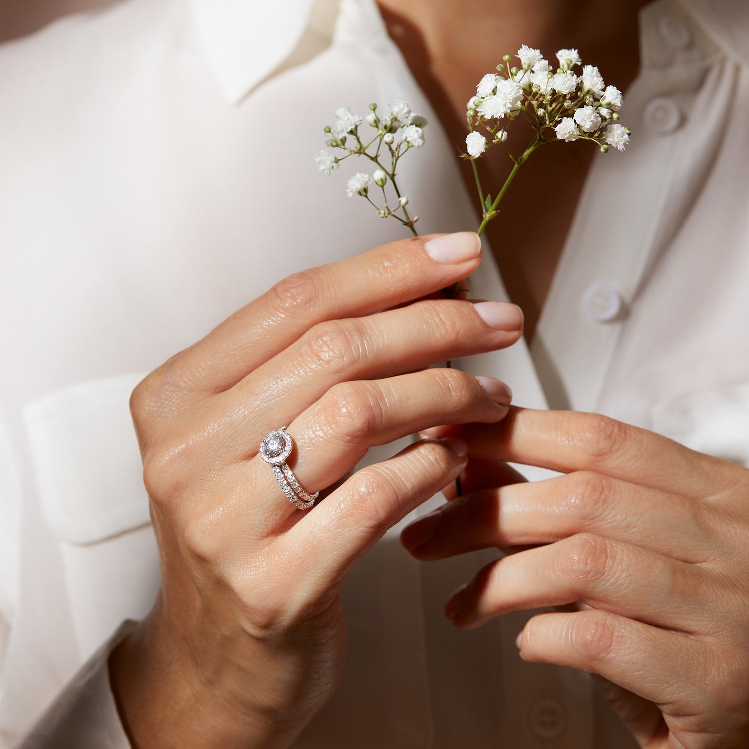Anello Camogli in oro bianco con diamanti rotondi indossato con fiori